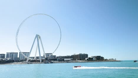 Boat-Passing-By-Dubai-Marina-And-Ferris-Wheel-In-Slow-Motion