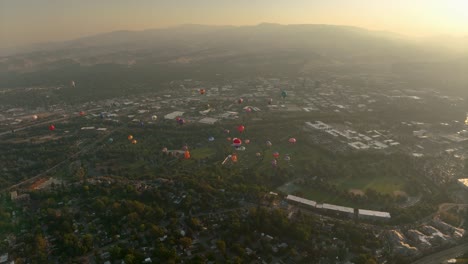 Wide-aerial-view-of-hot-air-balloons-soaring-in-a-hazy-sky-filled-with-wildfire-smoke