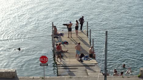 Young-guys-jumping-from-the-harbor-in-Guatemala,-Flores