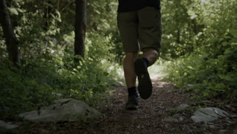 A-young-man-running-on-a-foresty-path-among-the-bushes-and-the-trees
