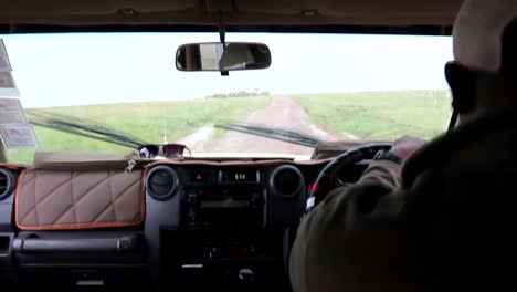African-man-driving-crossover-through-the-savanna-in-Africa