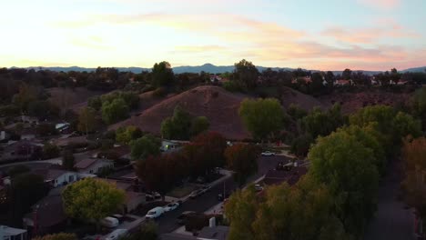 Aerial-Drone-Rising-Over-Valencia-Hills-In-Santa-Clarita,-USA,-With-Colorful-Sunset-Sky