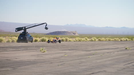 La-Cámara-De-Cine-Arm-Car-Sigue-Y-Filma-El-Coche-De-Fórmula-1-Conduciendo-Por-La-Pista-De-Un-Aeropuerto-En-Las-Vegas,-Nevada.