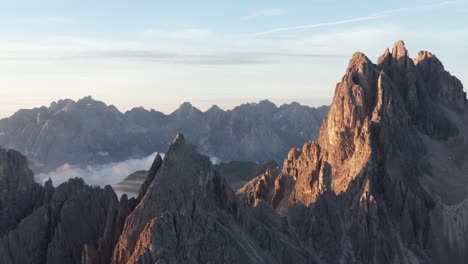 Aerial-tracking-shot-of-beautiful-mountain-range-with-rocky-summit-during-sunrise-in-Italy---Cadini-Di-Misurina,-Dolomites
