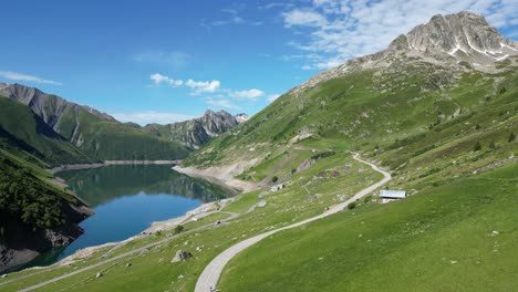 Scenic-Road-and-Mountain-Lake-in-French-Alps---Aerial-Dolly-Forward