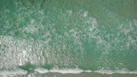 Aerial-view-above-people-on-a-sunny,-paradise-beach---cenital,-drone-shot