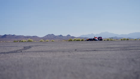 Formula-1-car-driving-down-an-airport-runway-in-Las-Vegas,-Nevada