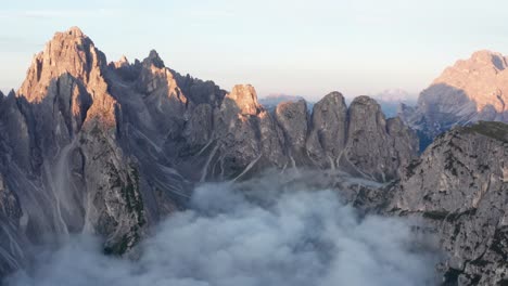 Dramatic-aerial-view-above-cloud-inversion-of-Cadini-di-Misurina-peaks,-sunrise