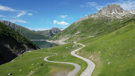 Scenic-Road-and-Mountain-Lake-in-French-Alps,-Isere-Savoy---Aerial-Pedestal-Up