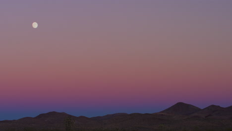 Moonrise-during-colorful-purple-sunset-in-the-desert-hills-of-Las-Vegas,-Nevada