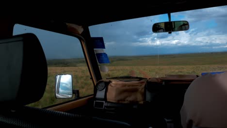 Schuss-Durch-Die-Windschutzscheibe-Des-Jeeps,-Der-Durch-Die-Savanne-In-Afrika-Fährt