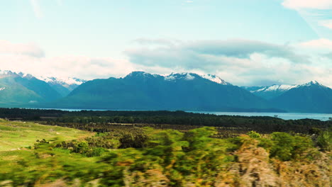 Road-tripping-in-New-Zealand,-Te-Anau-area:-mountains-covered-with-snow-rise-in-the-background