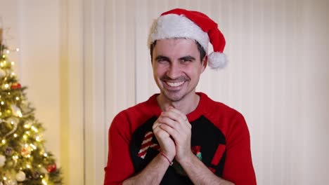 Crazy-man-wearing-Santa-hat-and-jumper-rubbing-hands-with-insane-grinning-and-laughing-facial-expression
