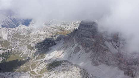 Dramatic-aerial-mountain-landscape-surrounded-by-clouds,-Rifugio-Locatelli-in-Tre-Cime-di-Lavaredo-Dolomites-area