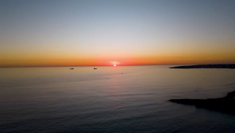 Timelapse-Aerial-View-Flying-Over-Ocean-Into-Dramatic-Sunset-near-Cascais-bay