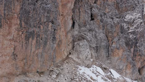 Mountain-climber-ascending-via-ferrata-Oskar-Schuster,-rocky-mountain-side,-Sassolungo-mountain-Dolomites,-Italy