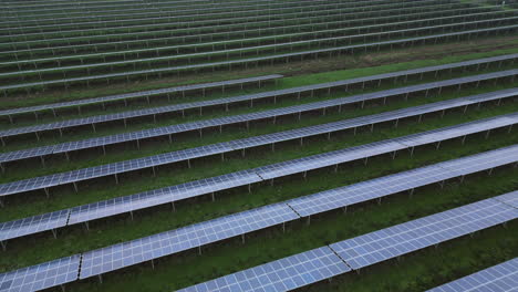 Solar-panels-in-solar-park,-rear-view,-endless-patterns,-diagonal-lines,-slow-drone-flight
