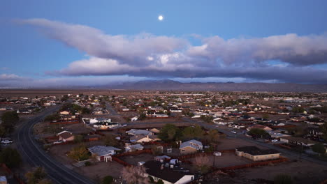 Kalifornische-Stadt-Im-Mojave-wüstenbecken-Szenische-Aufsteigende-Luftaufnahme-Mit-Dem-Vollmond-über-Den-Wolken