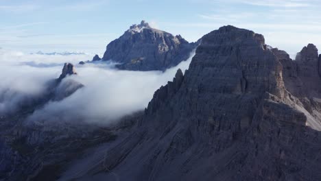 Cloud-inversion-in-valleys-of-majestic-Italian-Alps---drone-flight-among-rugged-mountain-peaks,-Sexten-Dolomites