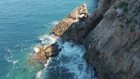 Waves-splashing-against-the-cliffside-of-Cala-Llonga-in-the-Belearic-islands,-Spain