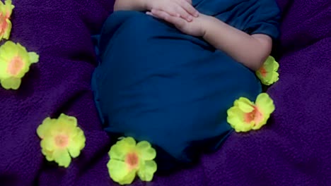 Süßes-Neugeborenes-Baby,-Das-In-Babywickel-Mit-Blumen-In-Einzigartigem-Stil-Aus-Der-Oberen-Winkelaufnahme-Schläft
