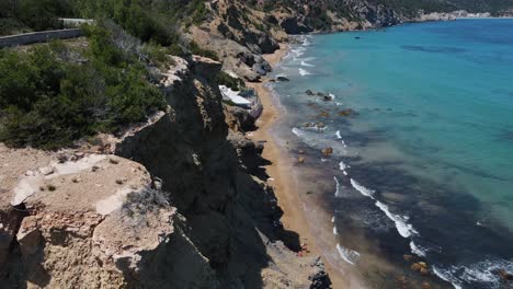 Luftaufnahme-über-Die-Schöne-Küste-Mit-Türkisfarbenem-Ozeanwasser-In-Ibiza,-Spanien