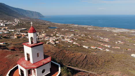 Aerial-shot-dolly-in-towards-the-hermitage-of-La-Caridad-on-the-island-of-El-Hierro-on-a-sunny-day