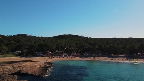 Aerial-drone-view-of-famous-beach-of-Cala-Bassa-in-ibiza,-pitiusa-island,-Spain