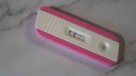 Nahaufnahme-Eines-Positiven-Rosa-Schwangerschaftstests-Auf-Der-Marmortischplatte