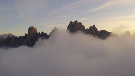 Montañas-Del-Tirol-Del-Sur-Rodeadas-De-Nubes-Vista-Aérea-Inversa-Sobre-Excursionista-Viendo-Hermoso-Paisaje