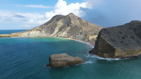 Atemberaubende-Luftaufnahme-Einer-Karibischen-Küste-Mit-Einem-Felsigen-Berg-Und-Einer-Beeindruckenden-Klippe,-Einem-Wunderschönen-Blauen-Himmel-Und-Meer