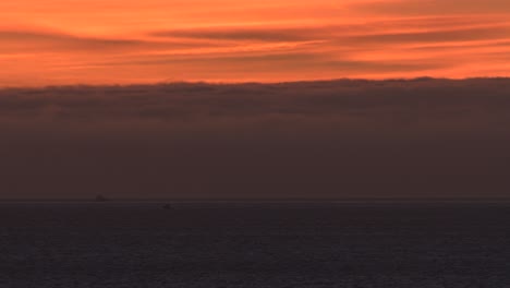 Sonnenuntergang-Auf-Dem-Flachen-Ozean-Mit-Dem-Boot,-Das-Sich-In-Der-Nähe-Von-Cascais-Marine-Bewegt