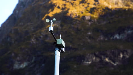 Automatic-weather-station-with-weather-monitoring-system,-against-majestic-mountain-range-of-New-Zealand