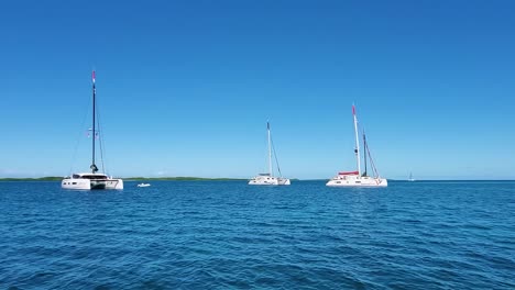 Crystal-clear-caribbean-sea-with-ancored-catamarans,-Los-Roques-Archipelago