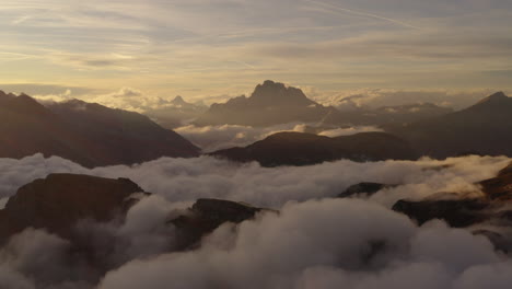 Heavenly-South-Tyrol-silhouette-mountains-surrounded-by-ethereal-sunrise-cloudscape-aerial-view
