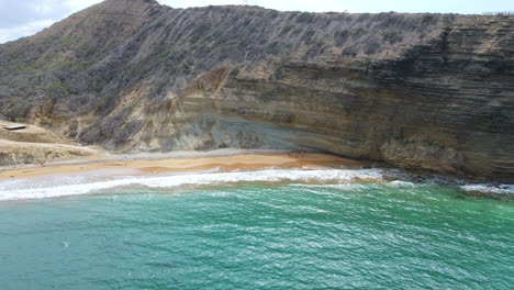 Impressive-panoramic-view-of-a-high-cliff-in-the-caribbean-coast-next-to-the-sea-with-a-stunning-small-beach