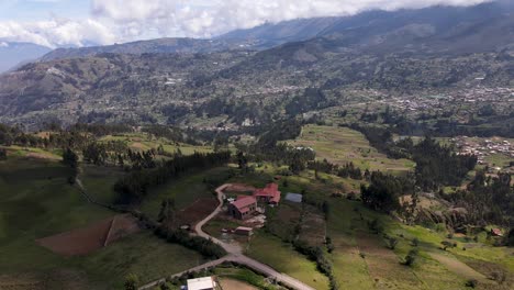 Aufschlussreiche-Drohnenaufnahme-Eines-Kleinen-Hauses-Auf-Einem-Hügel-Mit-Blick-Auf-Die-Weiten-Grünen-Hügel-Im-Hochland-Von-Peru