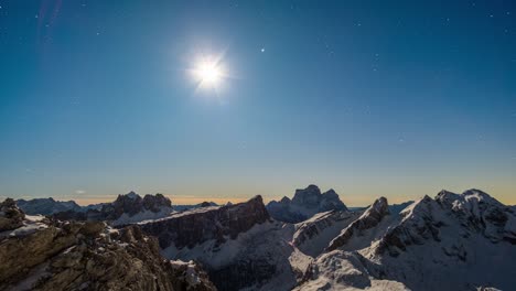 Time-lapse-panorama-of-lighting-full-moon-rising-up-at-night-sky-with-meteors-and-stars-over-snowy-mountains-of-Dolomites