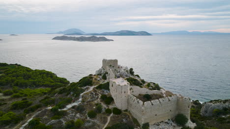 Drone-push-in-shot-toward-medieval-Kritinia-Castle,-islets-in-Aegean-Sea-behind