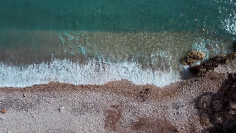 Top-down-aerial-view-of-paradisiac-tropical-beach,-turquoise-water-waves-splashes