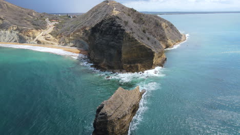 Aerial-view-of-a-caribbean-coast-with-stunning-color-and-a-big-rock-during-a-clear-beautiful-day
