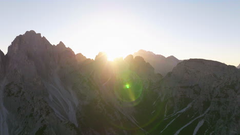 Sonnenstrahlen-Glühen-über-Südtirol-Tre-Cime-Berggipfel-Luftaufnahme-Langsam-Umkreisender-Gipfel