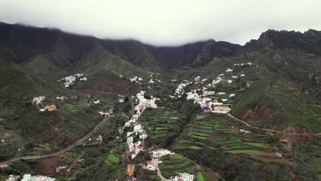 Aerial-panoramic-village-in-green-mountain-ridge-landscape,-Tenerife