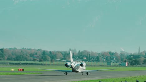 Private-Jet-taxiing-at-scenic-Austrian-airport-Salzburg-located-within-the-mountains