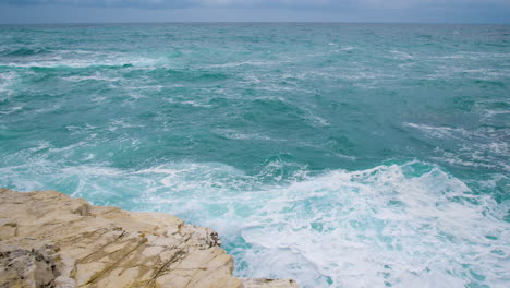 Waves-breaking-on-rt-Kamenjak-rocky-shore,-restless-sea