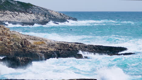 Big-sea-waves-crushing-on-rocky-shore,-restless-sea-on-stormy-and-windy-weather