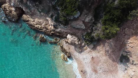 Paradisiac-hidden-bay-with-crystal-clear-tuquoise-water,-Sardinia,-aerial-static