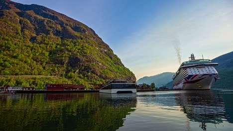 Low-angle-view-of-luxury-passenger-ships-docked-and-sailing-at-fjord-port-in-Flam,-Norway
