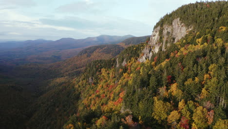 Fall-Foliage-Aerial-flight-by-cliff-in-Evans-Notch,-located-in-the-White-Mountains-of-Maine