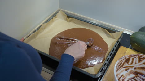 Woman-Filling-Baking-Tray-With-Chocolate-Brownie-Dough-in-Slow-Motion